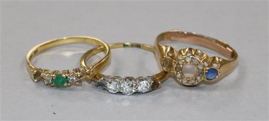 Three 18ct gold and gem set rings including three stone diamond and one lacking two stones.